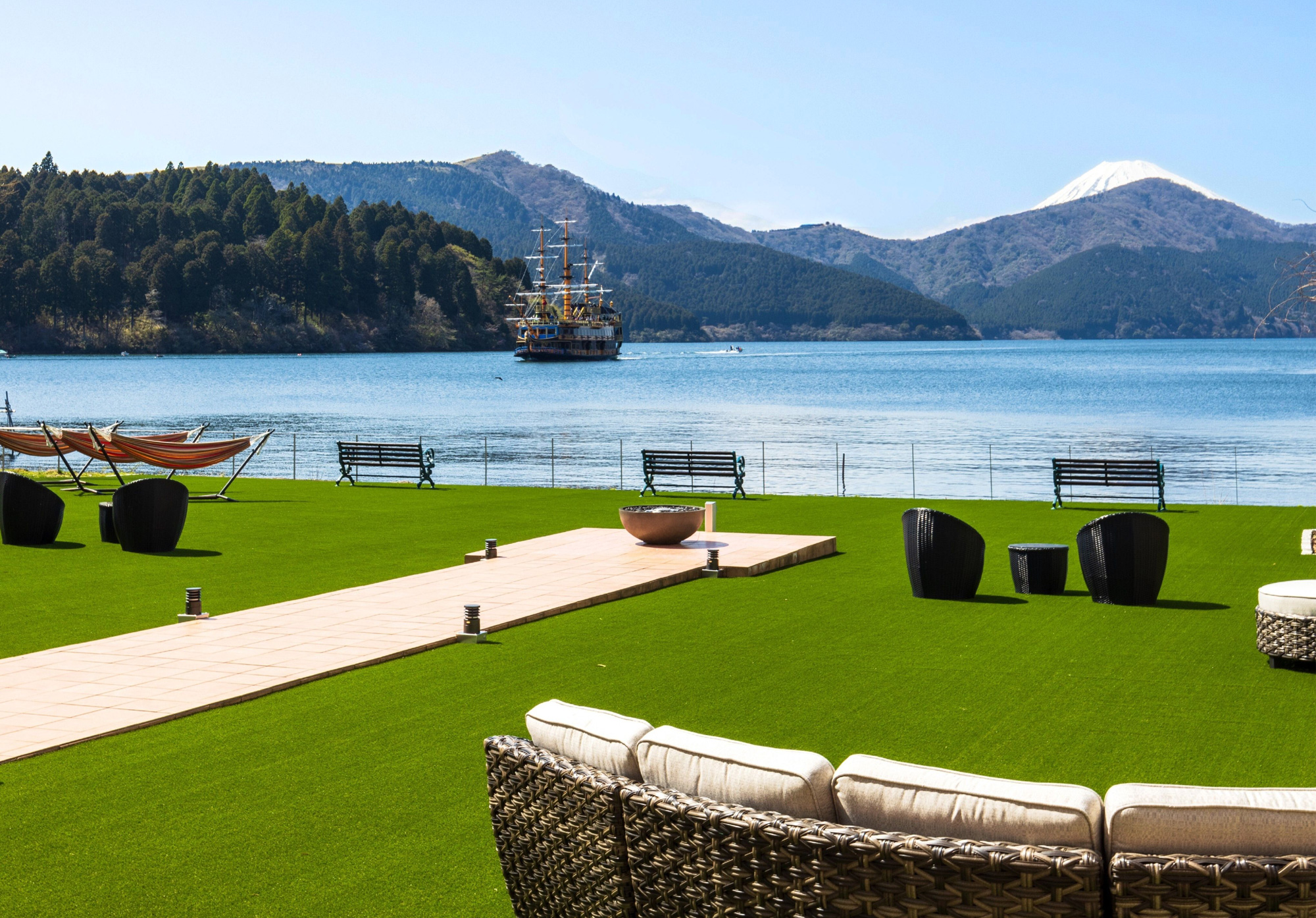 Hakone hotel exterior surrounded by blooming cherry blossoms and lush green mountains in spring season